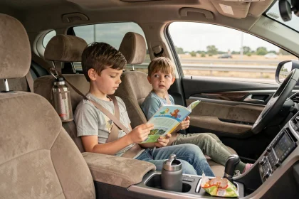 Enfants sagement installés dans un SUV familial pendant un voyage en voiture, lisant un livre d'activités avec ceintures attachées