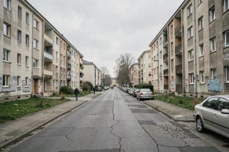 Rue d'un grand ensemble urbain à Toulouse avec des immeubles en béton des années 1970 et des trottoirs usés